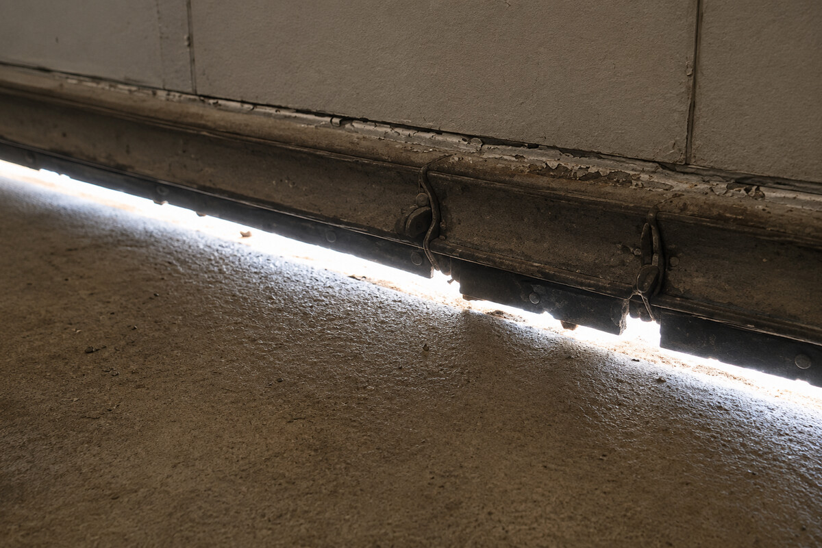 Cracked garage door bottom seal with a visible gap